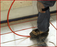 Installing tubing for hydronic radiant floor heating system.